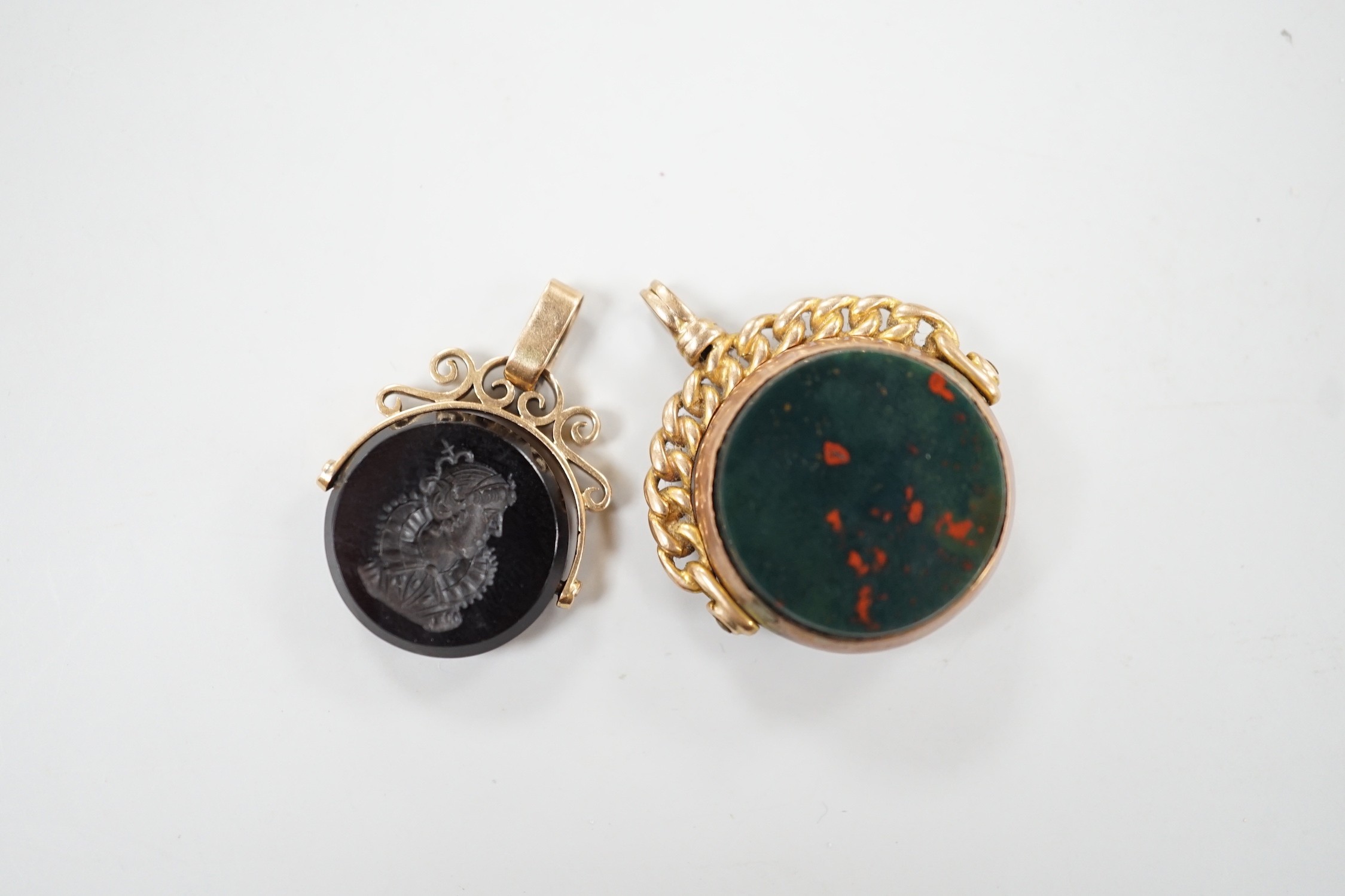 A late Victorian 9ct gold and bloodstone set spinning fob seal, 29mm and one other yellow metal and chalcedony set spinning fob seal.